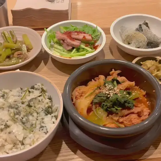 木のトレイに並ぶ韓国の定食と付け合わせ